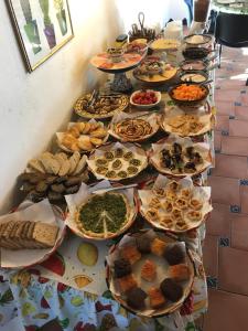 a long table with many plates of food on it at CA' LA SOMARA in San Pantaleo