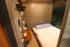 a small room with a bed and a window at Carefree Park in Taichung