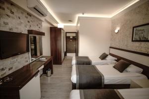een hotelkamer met 2 bedden en een flatscreen-tv bij Camyuva Beach Hotel in Kemer