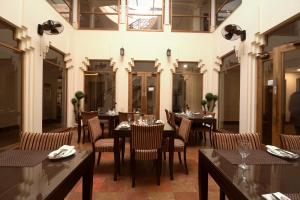 木尔坦Hotel One Tariq Road Multan的一间有桌椅的餐厅