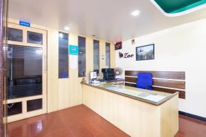 un bureau avec un comptoir de réception et une chaise bleue dans l'établissement hotelpearlinn, à Bangalore