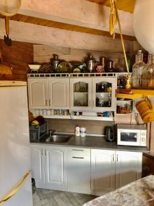 a kitchen with white cabinets and a sink at "Будиночок гедоніста" in Tukhlya