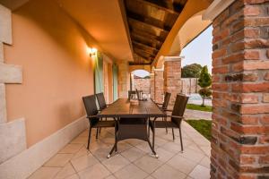 eine Terrasse mit einem Holztisch und Stühlen in der Unterkunft Luxury Villa Kras in Dobrinj