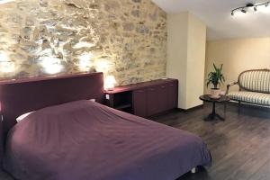 a bedroom with a bed and a stone wall at COEUR de GOUDARGUES! 3 ch, 3 SDB, Extérieur, CLIM in Goudargues