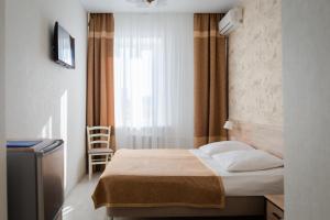 a small bedroom with a bed and a window at Priokskaya Hotel in Ryazan