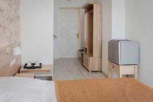 a room with a bed and a refrigerator in it at Priokskaya Hotel in Ryazan