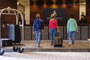 un grupo de tres personas caminando por una tienda con equipaje en Snö Aragon Hills, en Formigal