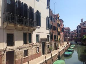 un canal en una ciudad con barcos en el agua en Casa del Pozzo, en Venecia