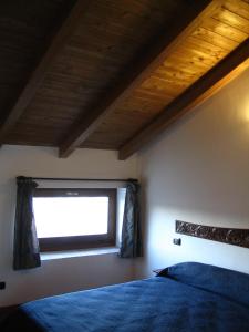 1 dormitorio con ventana y 1 cama azul en Guest House Pedamentina, en Nápoles