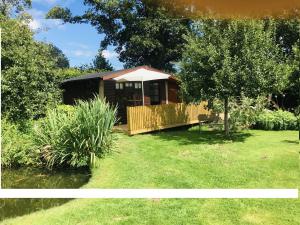 uma pequena cabina com um deque num quintal em The Cider Shed Bed and Breakfast em Wareham