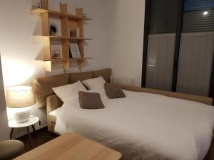 ein Schlafzimmer mit einem großen weißen Bett und einem Tisch in der Unterkunft L'Arbre in Le Mans