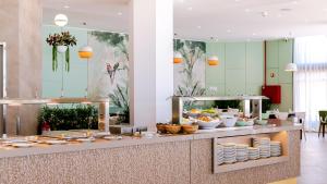 una línea de buffet con platos y tazones de comida en Auramar Beach Resort en Albufeira