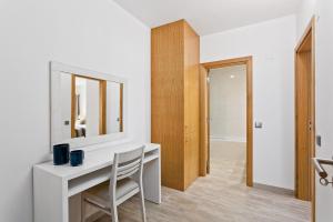 Habitación blanca con escritorio y espejo. en Vale San Antonio Apartments, en Almancil