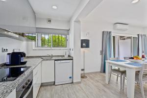 a white kitchen with a table and a counter top at Vale San Antonio Apartments in Almancil