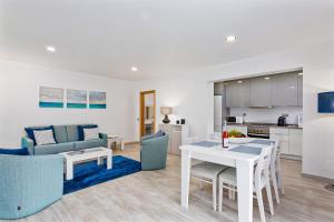 een keuken en een woonkamer met een tafel en stoelen bij Vale San Antonio Apartments in Almancil