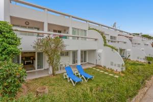 twee blauwe stoelen in de tuin van een gebouw bij Vale San Antonio Apartments in Almancil