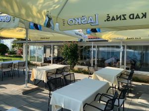 un groupe de tables et de chaises sous des parasols dans un restaurant dans l'établissement Vila Stosic, à Ražanac