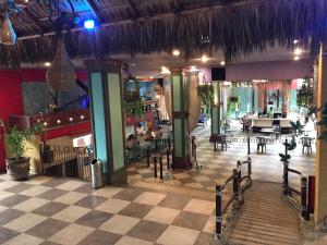 ein Restaurant mit kariertem Boden sowie Tischen und Stühlen in der Unterkunft Hotel Club del Sol Acapulco by NG Hoteles in Acapulco