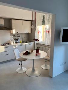 uma cozinha com uma mesa branca e 2 cadeiras em Birimari house em Arezzo