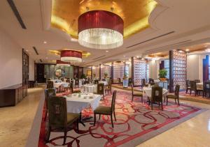 a restaurant with tables and chairs and a chandelier at Ming Cheng Hotel Fuzhou in Fuzhou