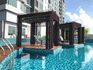 una piscina con terraza y un edificio en Kuantan Imperium by Glex, en Kuantan