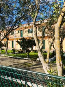a tree in front of a building with a fence at Banos Apartments and Swimming Pool STUDIO in Roda +30 photos
