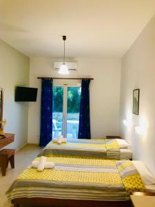 two beds in a room with a window at Room in Studio - Amazing 1 bed room apartment Banos and Swimming Pool in Roda