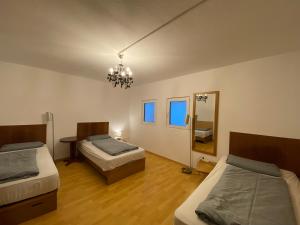 ハノーファーにあるEnglish Romance Langenhagenのベッド2台、鏡、シャンデリアが備わる客室です。