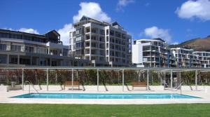 a large apartment complex with a swimming pool in front of buildings at One Bedroom Apartment - fully equipped Waterfront based in Cape Town