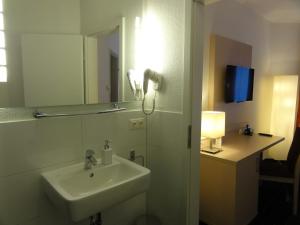 a bathroom with a sink and a mirror at Pension Zeitlos in Potsdam +37 photos
