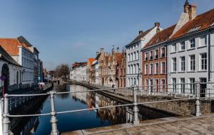 un puente sobre un río en una ciudad con edificios en B&B Anna9 en Bruges