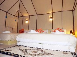 a bedroom with a white bed with a canopy at Room in Lodge - Sleep In Luxury Tent In Desert in Merzouga