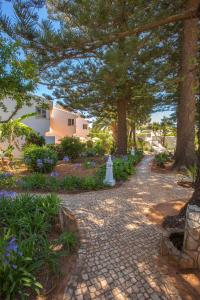 a brick pathway with trees and flowers in a yard at Quinta Paraiso da Mia - Two bedroom apartment in Luz