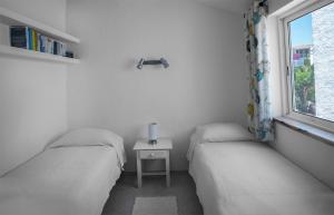 zwei Einzelbetten in einem Zimmer mit Fenster in der Unterkunft Stylish two bedroom apartment with garden vieuw in Luz + 5 Fotos