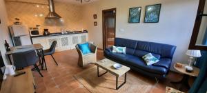 a living room with a blue couch and a table at Hacienda La buena vida B&B en appartementen casita la bruja in Algarinejo
