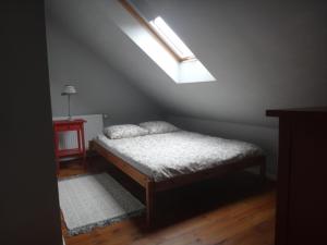 a small bedroom with a bed and a skylight at Domek Socałówka in Sułkowice