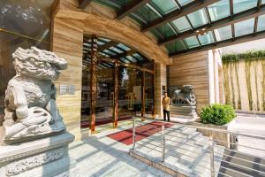 a man standing in front of a building with statues at Sherwood Suites in Ho Chi Minh City