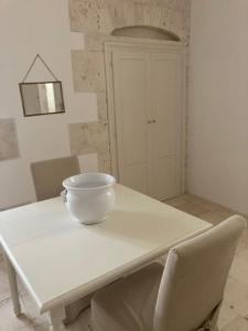 a white dining room table with a bowl on it at Masseria Torre Catena Resort & Restaurant in Polignano a Mare