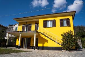 a yellow house with stairs on the side of it at Agricanto in Sestri Levante