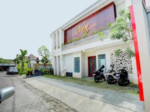 two motorcycles parked in front of a building at Super OYO Capital O 90291 Vin Stay Petanu in Pesanggaran