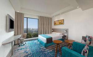 a hotel room with a bed and a couch at Holiday Inn Express Kolkata Airport, an IHG Hotel in Kolkata