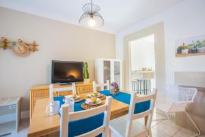 una sala da pranzo con tavolo e TV di Villa Salento a Torre Santa Sabina