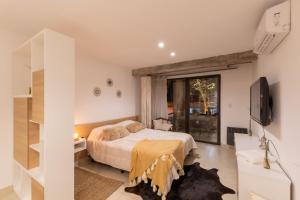 sypialnia z łóżkiem i telewizorem w obiekcie Cbmona Suites w mieście Villa Mercedes
