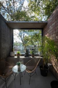 a patio with two chairs and a table and a window at Cbmona Suites in Villa Mercedes