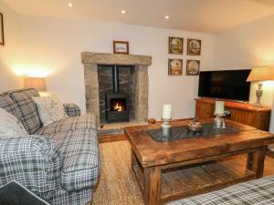 a living room with a couch and a fireplace at Croft Cottage in Matlock