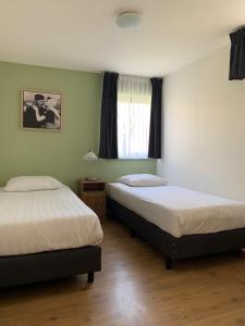 sypialnia z 2 łóżkami i oknem w obiekcie Les Maisons Domburg w mieście Domburg