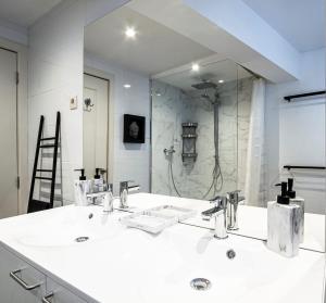 un bagno con due lavandini e un grande specchio di La Maison Bleue - Wellness - SPA a Spa Altre 4 foto