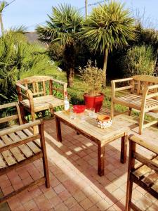 two chairs and a table and two benches on a patio at La Breizh'îlienne in Groix