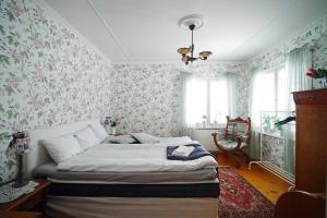 a bedroom with a bed with floral wallpaper at Villa Sisu in Överkalix