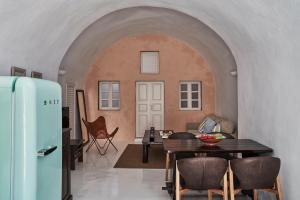 2 bedroom charming villa with outdoors jacuzzi في ميغالوخوري: غرفة معيشة مع طاولة وثلاجة